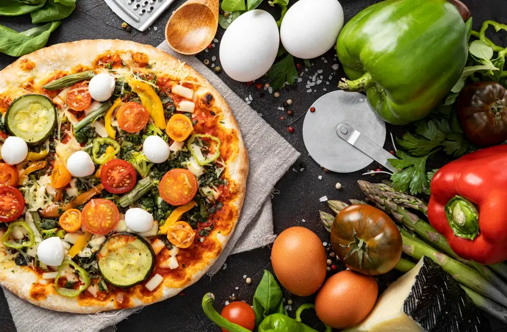 "Colorful veggie pizza with zucchini, cherry tomatoes, bell peppers, mozzarella balls, and fresh greens, surrounded by fresh vegetables and ingredients."