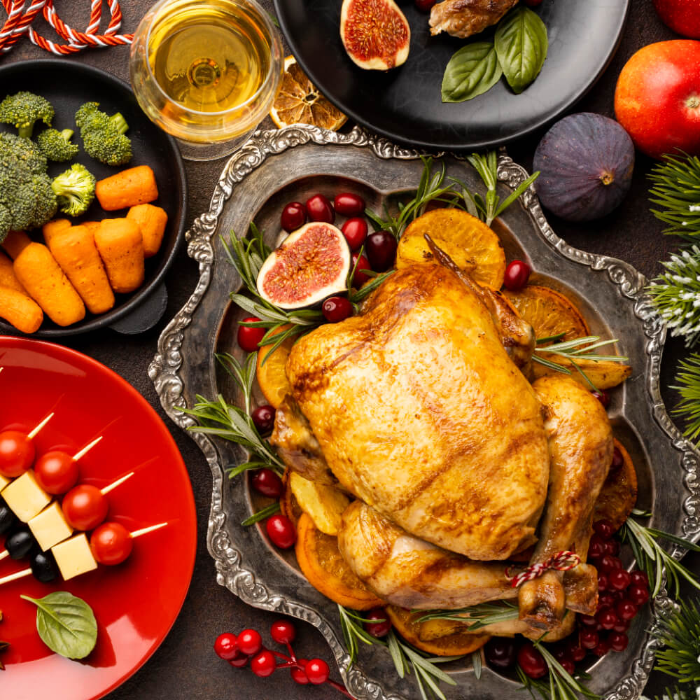 Golden roasted turkey surrounded by fresh rosemary, cranberries, figs, and orange slices, displayed with holiday side dishes and wine.